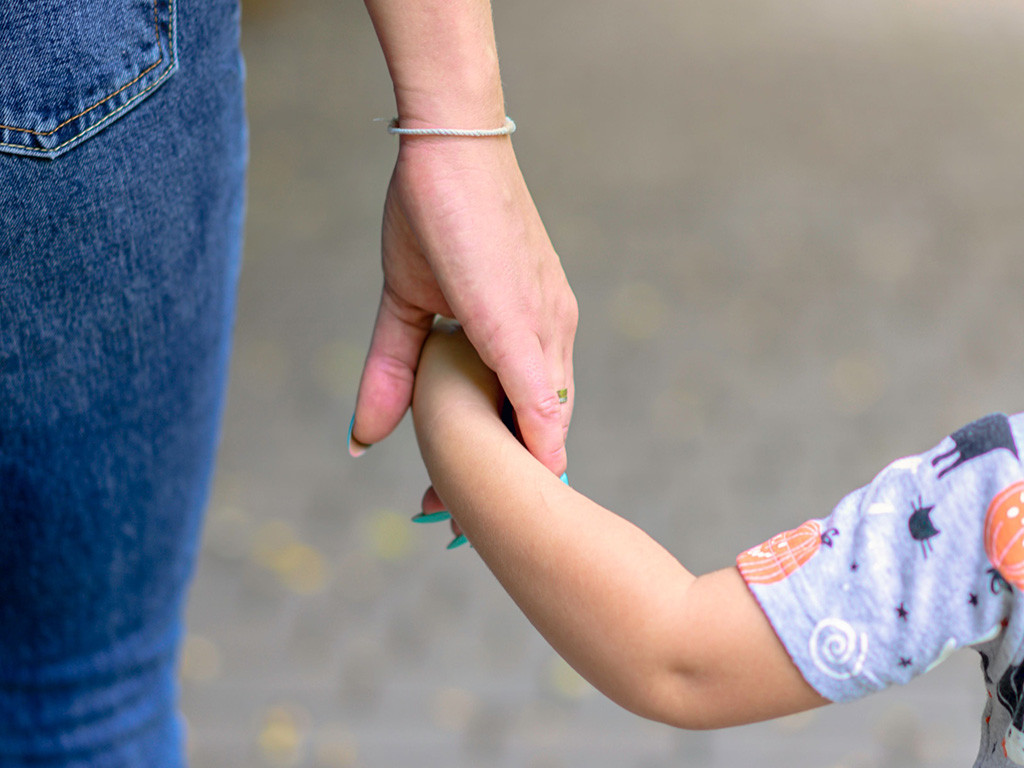 Adult holding a young child's hand