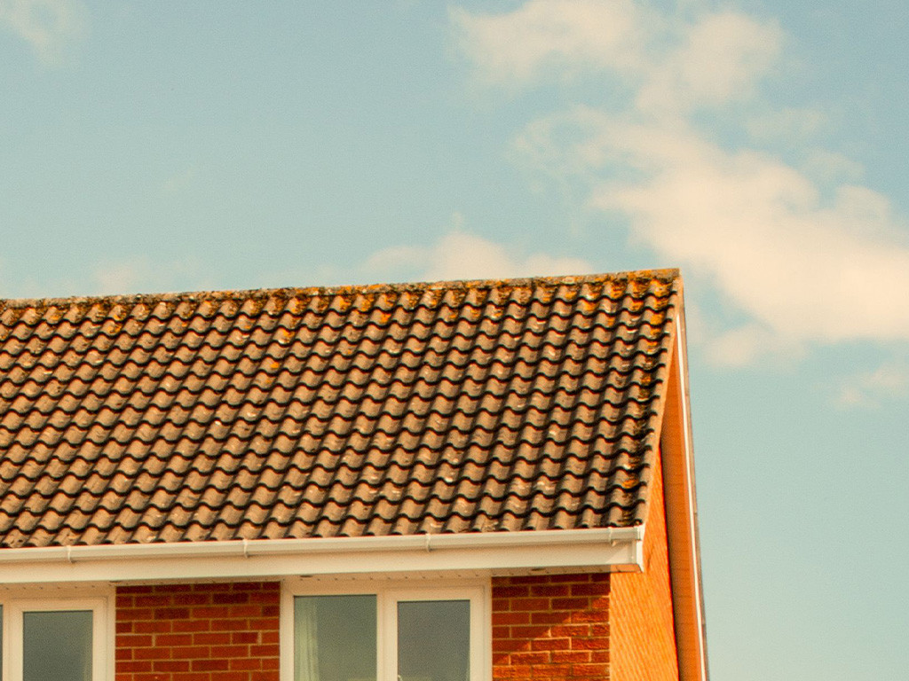 Red-brick family home against a blue sky