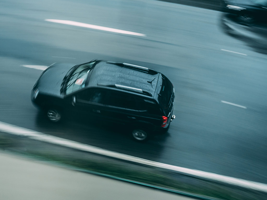 Car driving at speed on a wet road
