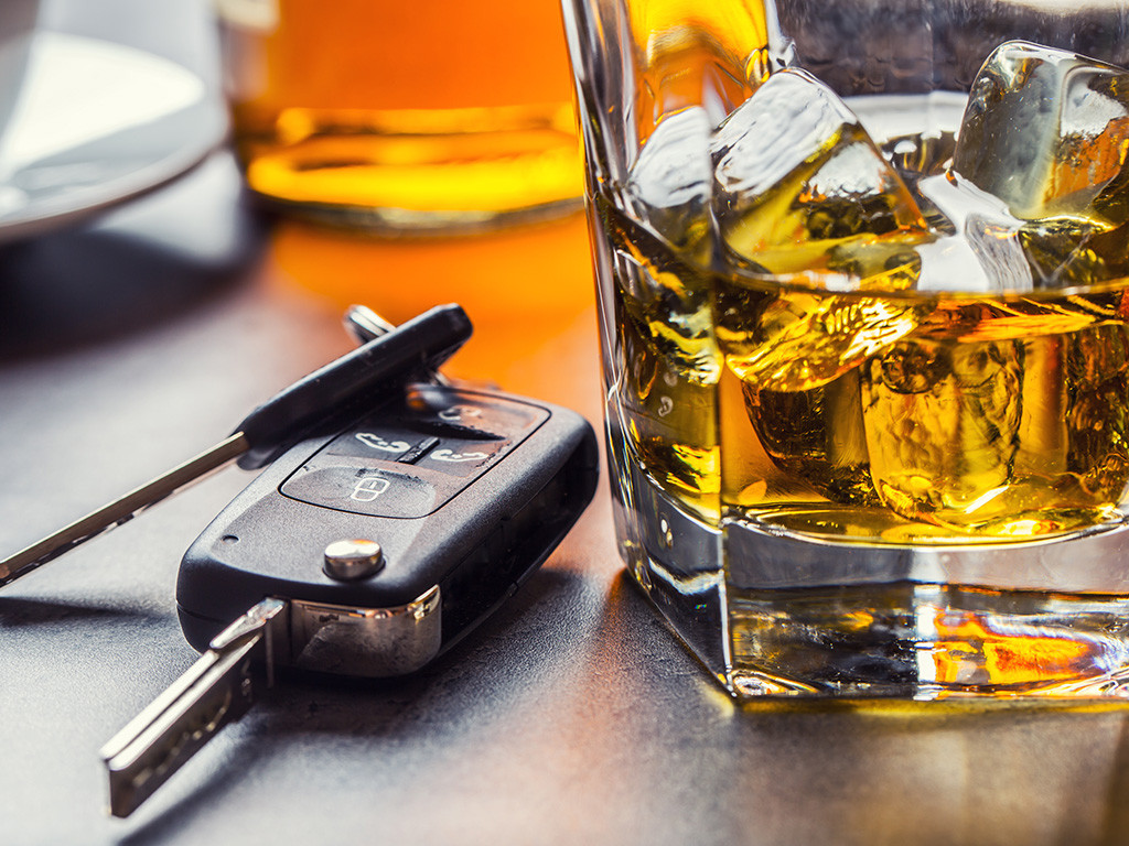 Car keys beside a glass of whisky