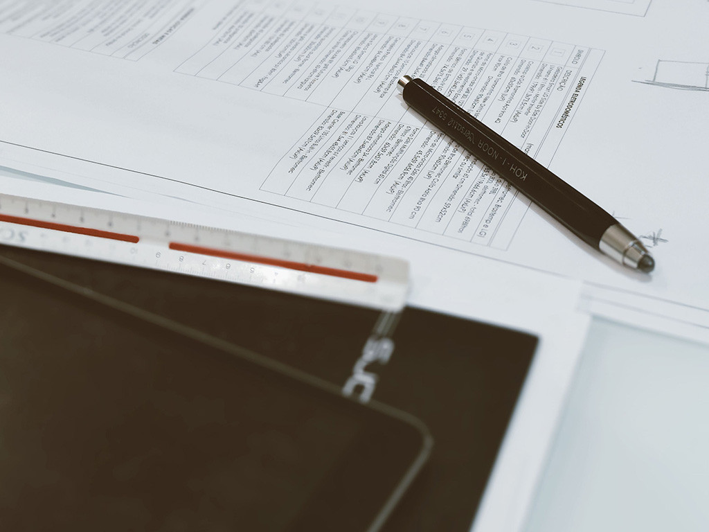 Pen, ruler and planning documents on a desk