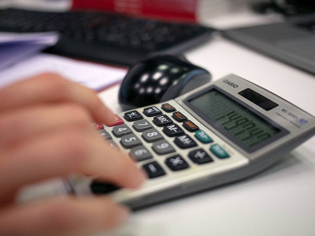 Hand working out figures on a calculator