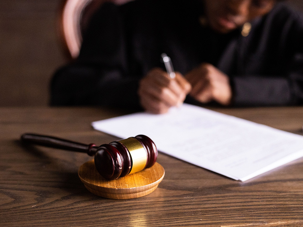 Gavel on a desk as a judge signs a document