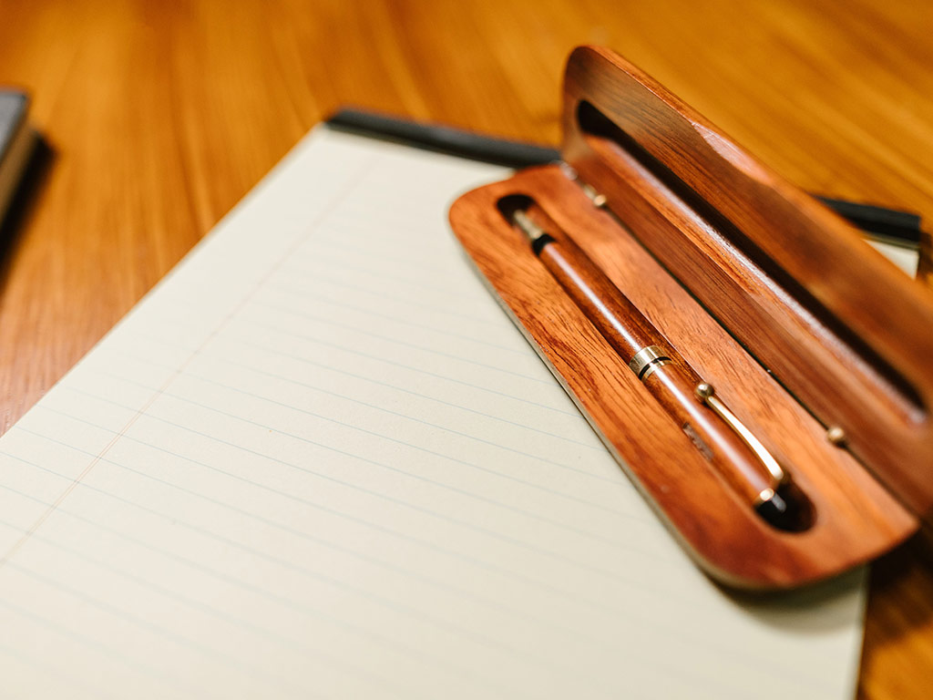 Fountain pen in a wooden case on a writing pad
