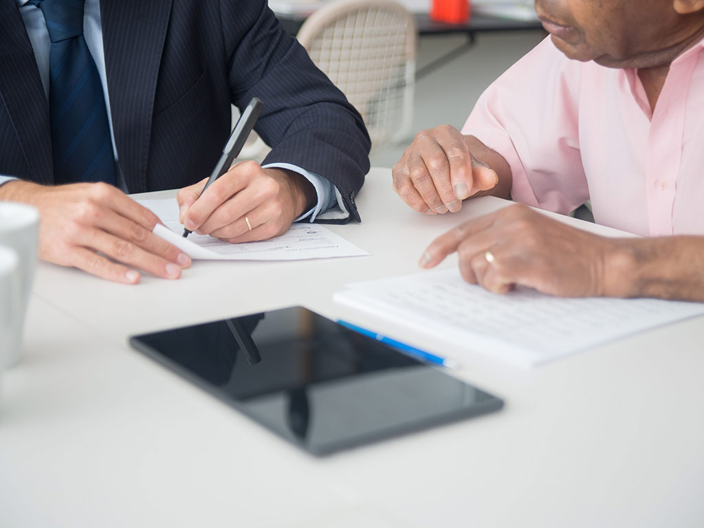 Adviser and client completing paperwork at a table