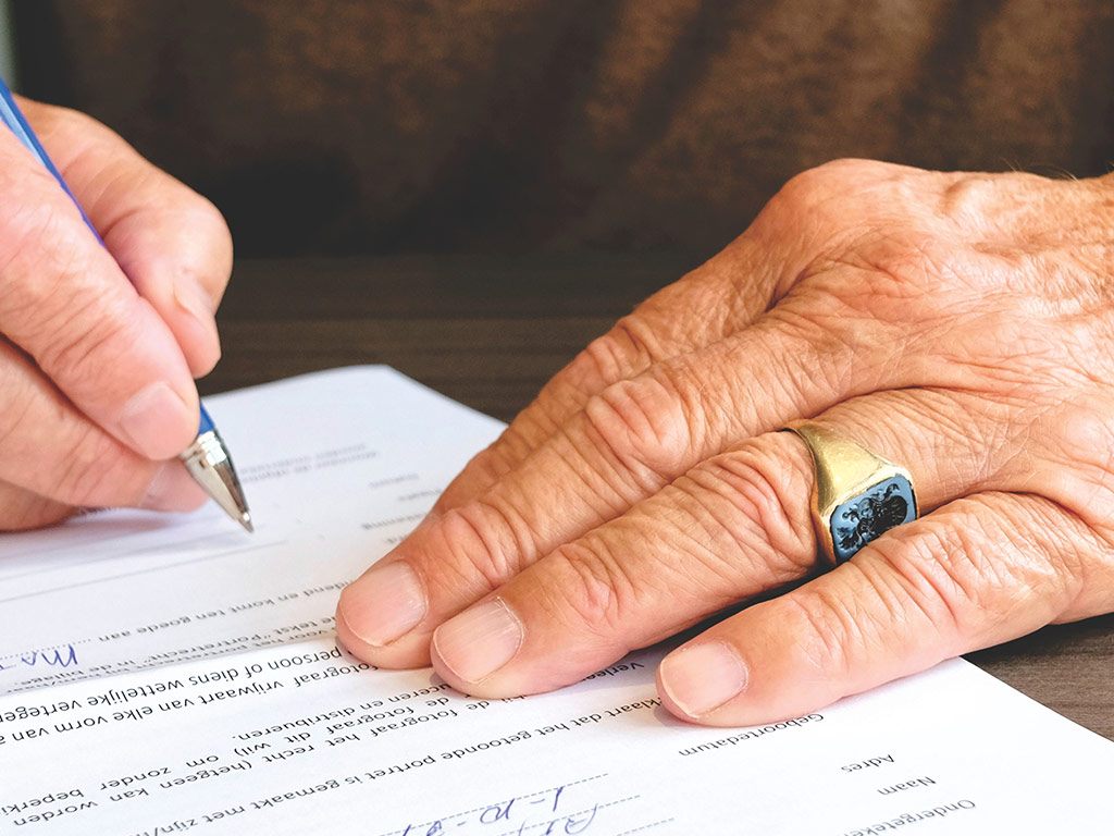 Older person signing a document